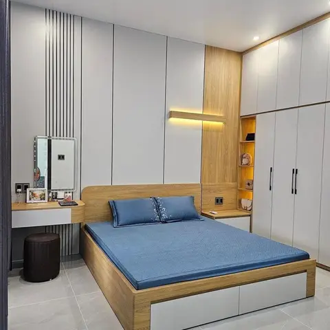 Bedroom with a fluted wood-and-white vertical panelled headboard wall, a backlit wall-mounted shelf niche, a full-height wardrobe