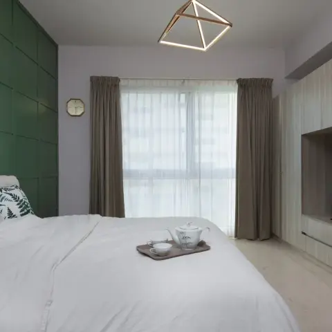 Bedroom with a forest-green grid-panelled headboard wall under a copper linear reading light, a geometric copper-frame pendant over the bed