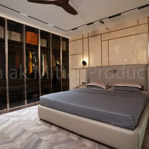 Bedroom with a full-height smoked-glass wardrobe on rose-gold profiles facing a leather bed