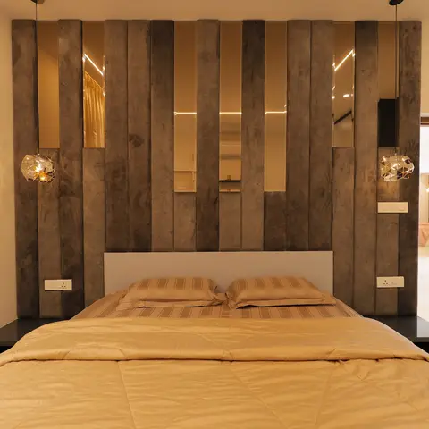 Bedroom with a full-height textured wood-slat headboard wall inset with vertical mirror strips and two faceted geometric pendant lights flanking the bed.