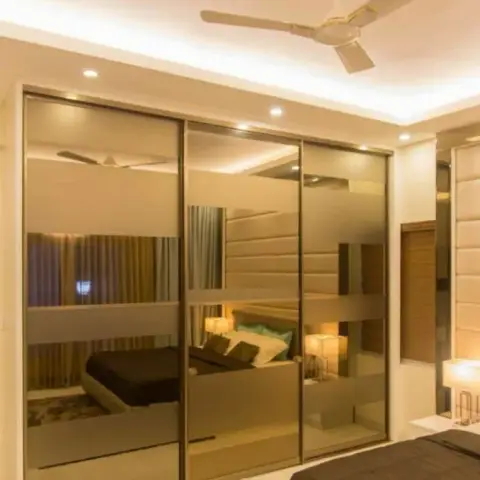 Bedroom with a full-width mirrored sliding-door wardrobe reflecting the bed, a cove-lit ceiling with a ceiling fan