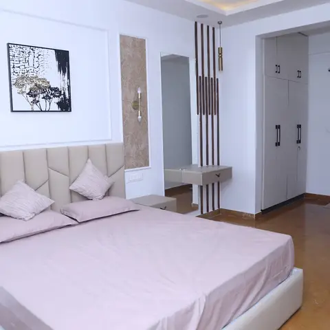 Bedroom with a geometric-channel blush headboard, a framed abstract painting in a moulded wall panel
