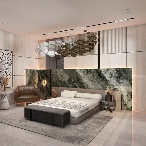 Bedroom with a green-marble headboard wall, sculptural disc chandelier and a tan leather accent armchair