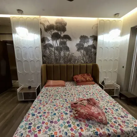 Bedroom with a mustard velvet channel-tufted headboard, backlit fluted panel columns on either side