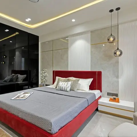 Bedroom with a red velvet upholstered bed, a mirrored black glass wardrobe wall, a fluted stone-textured headboard wall with gold trim
