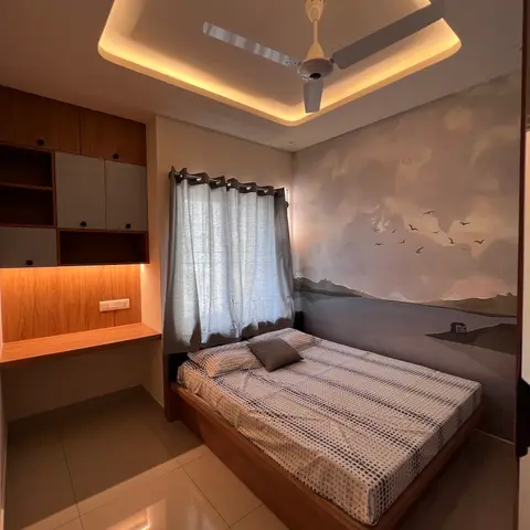 Bedroom with a scenic grey mural wallpaper of mountains and birds behind the bed, a cove-lit ceiling, sheer curtains
