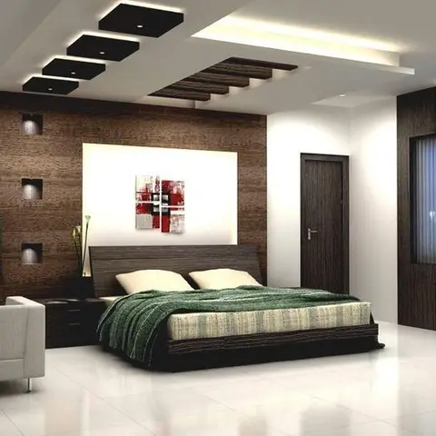 Bedroom with a stepped cubic false ceiling with cove lighting, a dark wood panelled headboard wall with a backlit abstract art niche