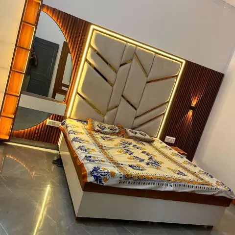 Bedroom with a tall cream upholstered headboard split by gold inlay strips and framed in a warm LED profile