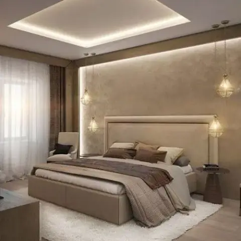 Bedroom with a tall upholstered beige headboard flanked by hanging pendant lights, a backlit textured accent wall