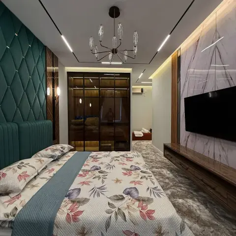 Bedroom with a teal diamond-tufted upholstered headboard wall, a sputnik chandelier, a marble slab TV feature wall