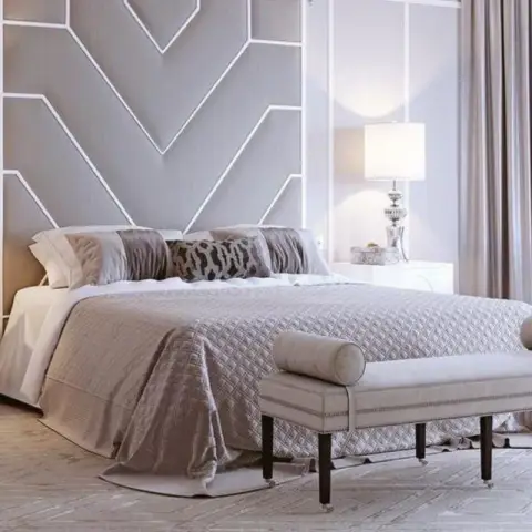 Bedroom with a two-tone chevron wall moulding headboard treatment, mirrored nightstands