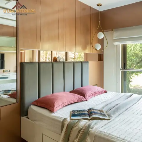 Bedroom with a vertical wood-panelled wall, a channel-tufted grey headboard, dusty pink pillows