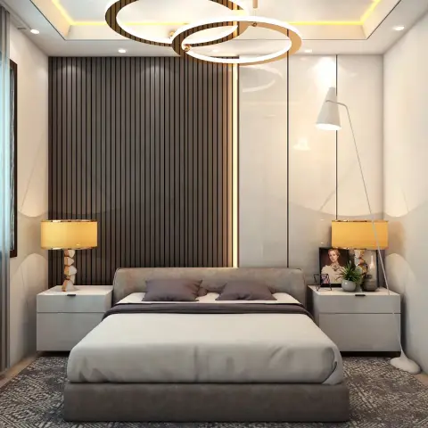 Bedroom with a vertical wood-slat accent wall behind an upholstered bed, matching brass table lamps on white nightstands, a ring-cluster pendant chandelier