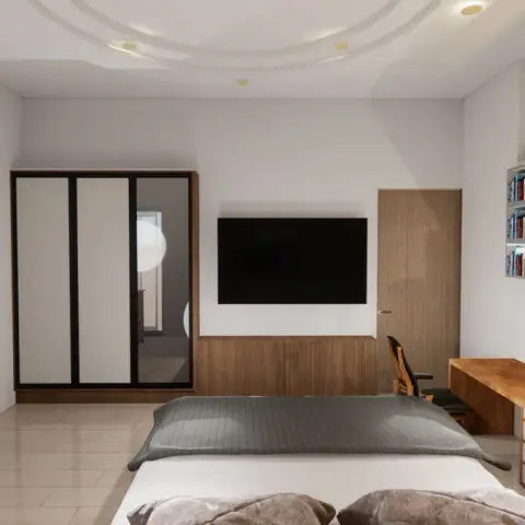 Bedroom with a wall-mounted TV above a teak dado, a long built-in desk running to the corner and three warm-lit book niches on the side wall.
