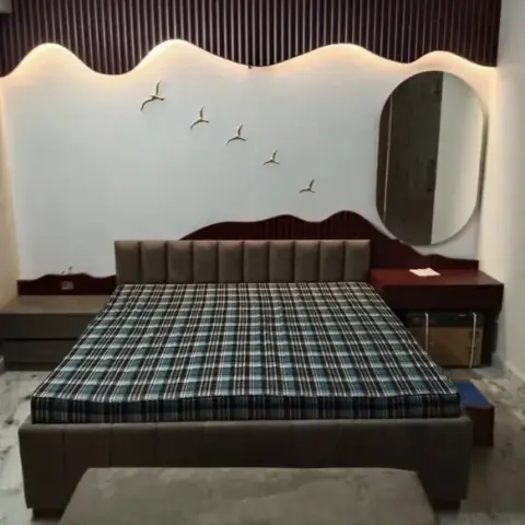 Bedroom with a wave-shaped fluted wood panelled headboard wall, cove lighting, a flock of bird wall art, and a round mirror beside the bed.