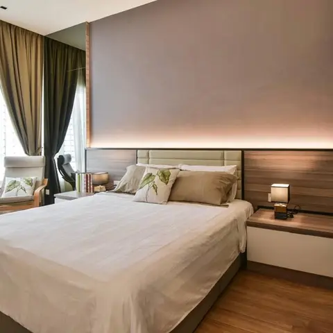 Bedroom with a wood-panel headboard wall lit by a cove light strip along the top, a floating wood-and-white nightstand, heavy olive curtains over sheers
