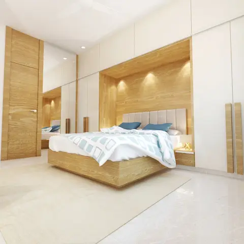Bedroom with a wood veneer headboard niche lit by recessed cove lighting, a channel-tufted headboard, and a glossy white wardrobe wall.