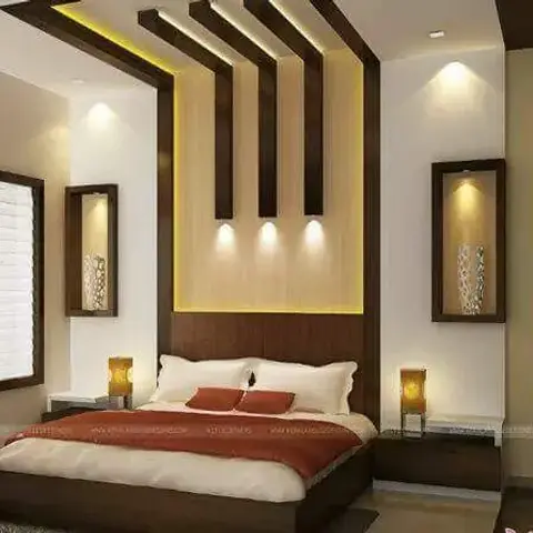 Bedroom with an angular wood-panelled cove-lit ceiling feature descending onto the headboard wall, flanked by symmetric nightstand lamps and wall-niche vases