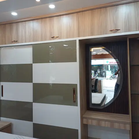 Bedroom with an olive-and-white checkerboard sliding wardrobe beneath wood-grain overhead cabinets