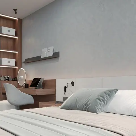 Bedroom with an upholstered white headboard against a textured grey plaster wall, a built-in dressing table with a round LED mirror