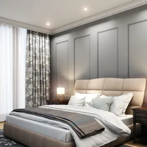 Bedroom with grey panel moulding on the headboard wall flanked by matching dark wood nightstands and brass table lamps