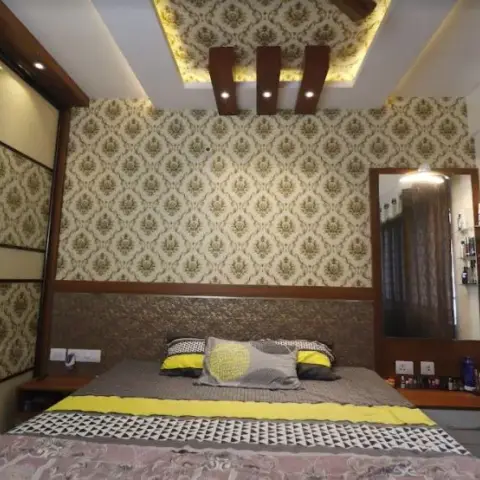 Bedroom with matching olive damask wallpaper on the headboard wall and sliding wardrobe doors