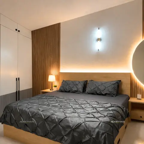 Bedroom with vertical fluted wood panelling, an open display shelf, and a large backlit round mirror beside the headboard wall.