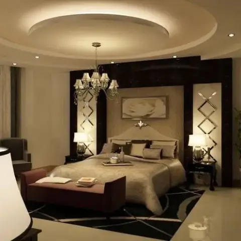 Beige bedroom under a circular cove-lit POP ceiling, with a crystal chandelier over the bed and mirrored diamond-lattice strips flanking a dark wood headboard