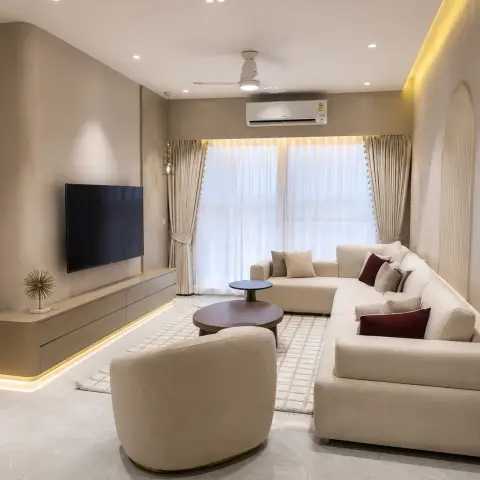 Beige living room where a curved-cornered textured plaster TV wall carries a floating console lit by a floor-level LED strip