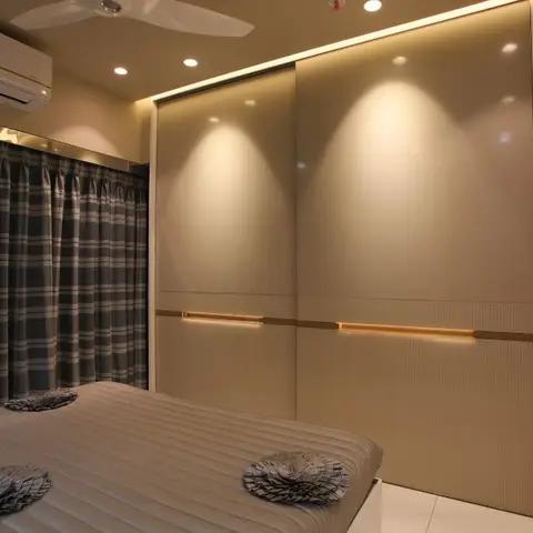 Beige sliding wardrobe with a continuous lit handle groove over a fluted lower band, ending in a tall arched mirror strip