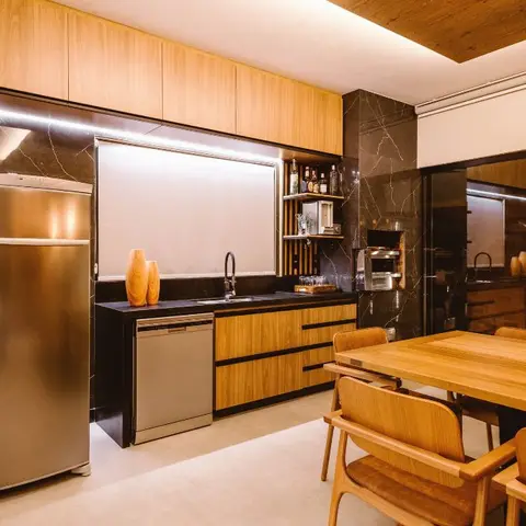 Black marble-clad kitchen with wood-laminate cabinetry, a stainless steel fridge and dishwasher