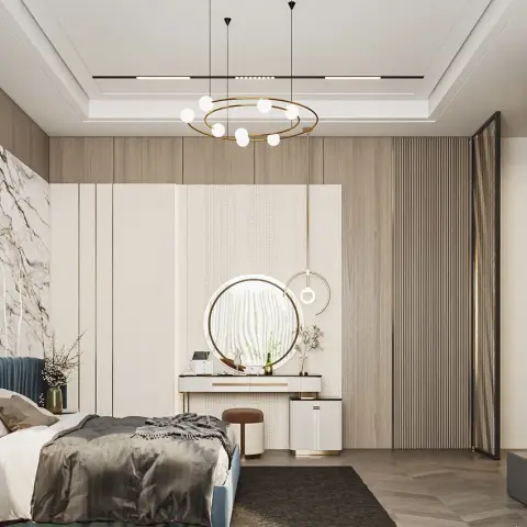 Blue channel-tufted bed set against a book-matched marble slab and a cream fluted wardrobe run, with a round backlit dressing mirror