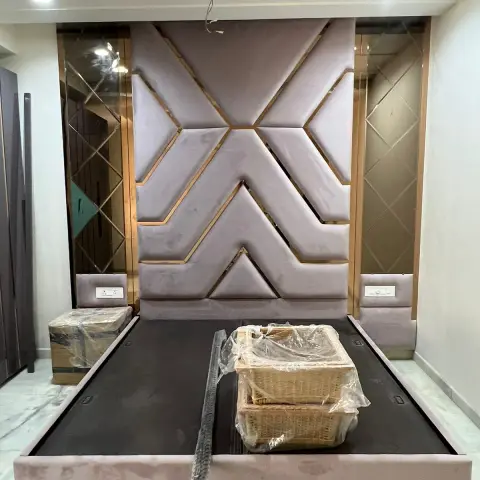 Blush velvet headboard wall cut into a chevron pattern with rose-gold inlay strips, bronze bevelled mirror bays either side