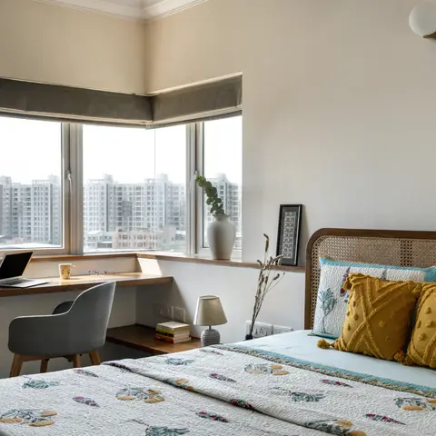 Boho bedroom with a rattan cane headboard bed dressed in mustard tasseled cushions and a floral quilt