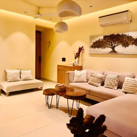 Boho living room with a beige L-shaped sofa styled in macrame and knit cushions, live-edge wood nesting coffee tables on hairpin legs, a woven jute pouf