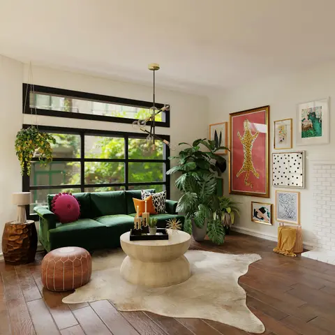 Boho living room with an emerald velvet sofa, leather pouf and cowhide rug around a round wood pedestal coffee table