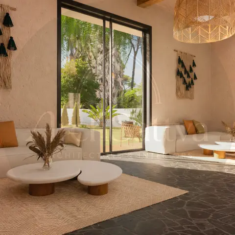 Boho living room with plastered walls, macrame tassel wall hangings, a woven rattan pendant light