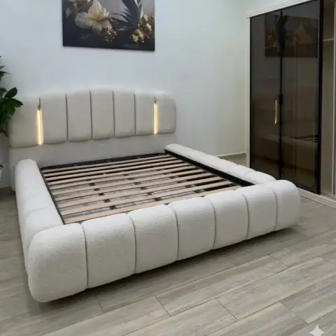 Boucle-upholstered platform bed with a channel-tufted headboard and inset LED strips, slats bare with no mattress