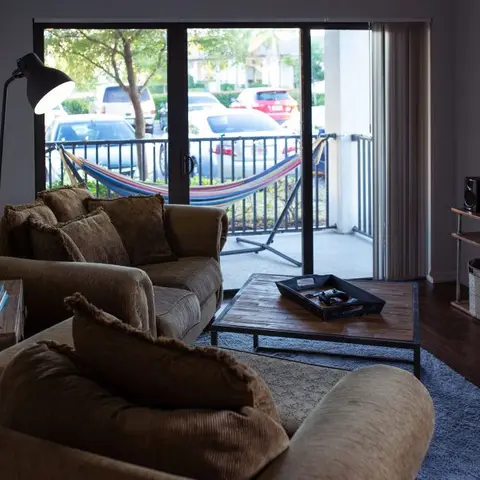 Brown corduroy sofas around a wood-and-metal crate coffee table facing a TV console with woven storage baskets