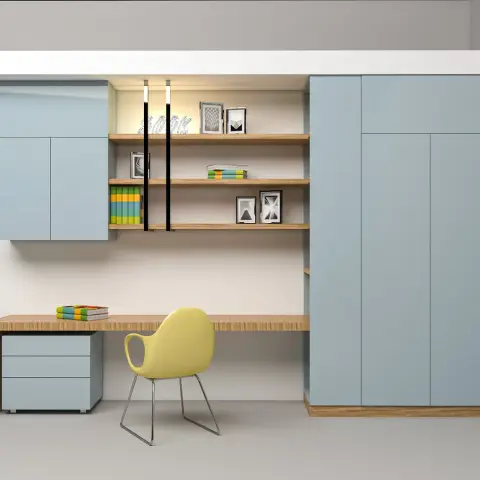 Built-in study desk with open display shelving and a pastel-blue wardrobe wall, paired with a mustard-yellow accent chair.