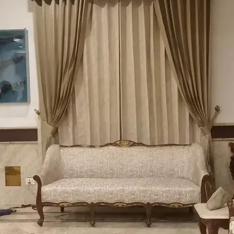 Carved-wood traditional sofa set beneath a beige pelmet-box curtain, on marble flooring with a diamond inlay pattern.