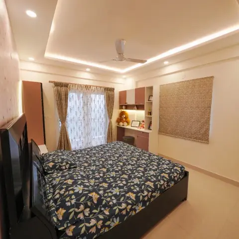 Child's bedroom with a pale pink star-and-cloud wallpaper wall, a floral-print bedspread on a dark bed