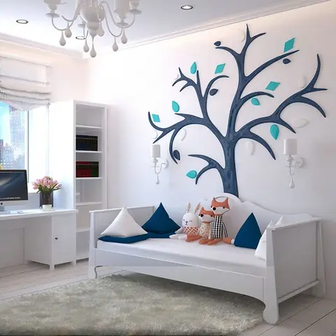 Child's bedroom with a single bed styled with plush animal toys beneath a decorative branch wall decal, beside a white study desk.