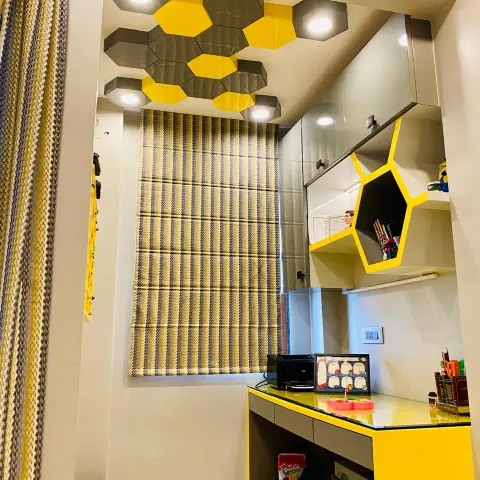 Child's study nook under a honeycomb ceiling of yellow and grey hexagon drop boxes, each with its own spot