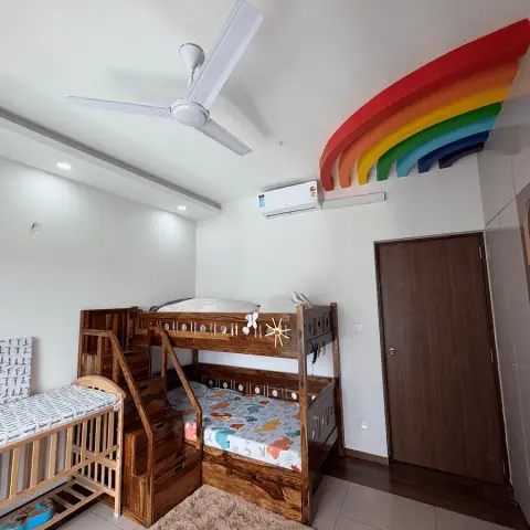 Children's room with a solid sheesham bunk bed and step-drawer staircase next to a wooden cot, under a layered rainbow sculpture mounted above the split AC