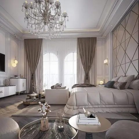 Classic-style master bedroom with a diamond-quilted upholstered wall behind the bed, arched draped windows and a crystal chandelier.