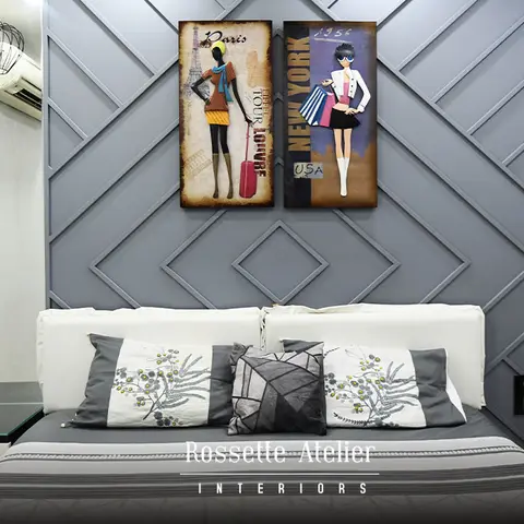 Compact bedroom whose grey headboard wall is worked into a diamond-and-chevron moulded pattern