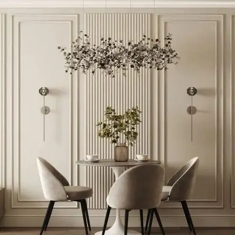 Compact dining nook with a round marble-top table and taupe velvet chairs set against a fluted panel backdrop flanked by moulded wall panels and a branch-style