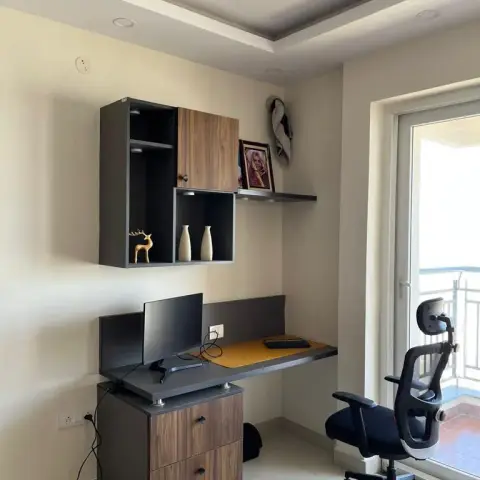 Compact home work corner with a grey-and-walnut wall-hung study unit, open display cubbies lit by mini spots