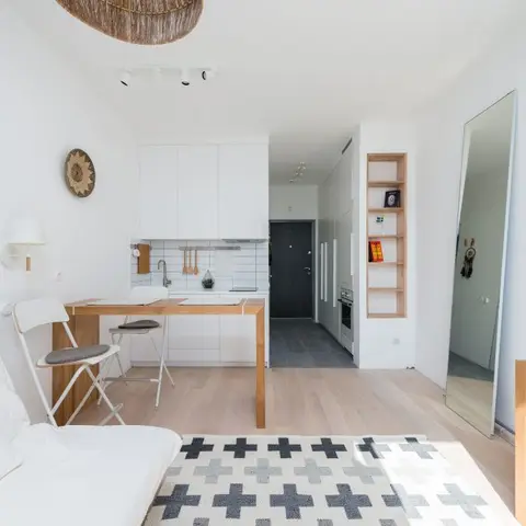 Compact studio apartment showing the living corner, dining table, small kitchenette